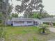 Exterior view of a house with a carport, red shutters, and a well-maintained lawn at 2529 Cr 448, Lake Panasoffkee, FL 33538