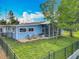 Charming home featuring a screened-in porch, fenced yard, and well-manicured lawn at 26619 Bimini Dr, Tavares, FL 32778