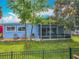 Charming home featuring a screened-in porch, fenced yard, and well-manicured lawn at 26619 Bimini Dr, Tavares, FL 32778