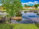 Well-manicured backyard featuring a waterfront view, private dock, and lush landscaping at 26619 Bimini Dr, Tavares, FL 32778