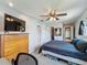 Comfortable bedroom with carpet, ceiling fan, dresser, and a closet with a mirror on the door at 26619 Bimini Dr, Tavares, FL 32778