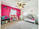 bedroom with pink accent wall, ceiling fan, and playroom decor at 26619 Bimini Dr, Tavares, FL 32778