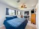 A comfy bedroom featuring carpet, ceiling fan, TV, a window and a full-sized bed at 26619 Bimini Dr, Tavares, FL 32778