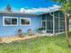 Charming home with a blue exterior, lush lawn, and screened-in patio, ideal for outdoor living at 26619 Bimini Dr, Tavares, FL 32778