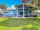 Charming home featuring a backyard with a covered patio, grill, and waterfront views at 26619 Bimini Dr, Tavares, FL 32778