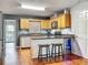 Well-lit kitchen with a breakfast bar, wood cabinets, granite countertops, and stainless steel appliances at 26619 Bimini Dr, Tavares, FL 32778