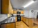 Eat-in kitchen featuring granite countertops, black appliances, wood cabinets, and wood flooring at 26619 Bimini Dr, Tavares, FL 32778
