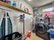 Practical laundry room features a modern washer and dryer, storage shelving, and cleaning supplies at 26619 Bimini Dr, Tavares, FL 32778