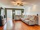 Bright living room with a large sofa, hardwood floors, and a ceiling fan at 26619 Bimini Dr, Tavares, FL 32778