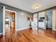 Relaxing sitting room featuring built-in bookshelves and wood floors, with an entrance to a kitchen at 26619 Bimini Dr, Tavares, FL 32778