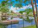 Scenic waterfront view of homes with boat docks and lush greenery, reflecting in the calm water at 26619 Bimini Dr, Tavares, FL 32778