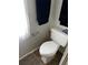 Compact bathroom with a toilet, white privacy curtains, and essential fixtures for basic needs at 313 Palo Verde Dr, Leesburg, FL 34748
