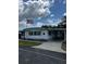 Charming single-story home with well-maintained landscaping, an American flag and long carport at 313 Palo Verde Dr, Leesburg, FL 34748