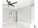 Bedroom with a modern ceiling fan, a bright window, and sleek gray color scheme at 316 Betty Ln, Mascotte, FL 34753