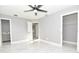 Bright bedroom with open doorway to closet, modern ceiling fan, and sleek gray walls at 316 Betty Ln, Mascotte, FL 34753