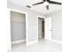 Bedroom featuring tile floors, gray walls, ceiling fan and an open closet at 316 Betty Ln, Mascotte, FL 34753