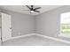 Bedroom featuring a modern ceiling fan, a bright window, and sleek gray color scheme at 316 Betty Ln, Mascotte, FL 34753