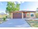 Charming single-story home featuring a brown garage door, manicured lawn, and freshly painted exterior at 316 Betty Ln, Mascotte, FL 34753