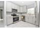 Stainless steel appliances accent this modern kitchen with white cabinets and granite countertops at 316 Betty Ln, Mascotte, FL 34753