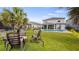 Expansive backyard features an inviting fire pit, a pool, lush green lawn, and mature trees at 3235 Buoy Cir, Winter Garden, FL 34787