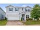 Beautiful two-story home featuring light blue siding, blue shutters, and brick paver driveway at 3235 Buoy Cir, Winter Garden, FL 34787