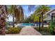 A tranquil pool area features lush tropical landscaping, lounge chairs, and a brick-paved walkway at 3235 Buoy Cir, Winter Garden, FL 34787