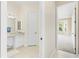 View through open doors to a full bathroom with tile flooring, a vanity, and a separate bedroom at 33222 Irongate Dr, Leesburg, FL 34788
