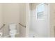 Bathroom featuring a toilet with handrails and a walk-in shower with white tiles and a window at 33222 Irongate Dr, Leesburg, FL 34788