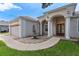 Attractive front entrance with elegant pillars, a decorative fountain, and a well-manicured lawn at 33222 Irongate Dr, Leesburg, FL 34788