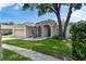 Beautiful front elevation featuring a manicured lawn, decorative fountain, and a two-car garage at 33222 Irongate Dr, Leesburg, FL 34788