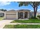 Charming single-story home with a well-manicured lawn, attached garage, and inviting front entrance at 33222 Irongate Dr, Leesburg, FL 34788