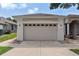 Close-up of a two-car garage door with decorative windows and exterior lighting fixtures at 33222 Irongate Dr, Leesburg, FL 34788