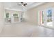 Living room features a tray ceiling, carpet, built-in shelves, and access to the lanai at 33222 Irongate Dr, Leesburg, FL 34788