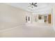 Large living room with a tray ceiling, carpet flooring, and view to the kitchen at 33222 Irongate Dr, Leesburg, FL 34788