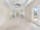Living room features a tray ceiling, carpet, built-in shelves, and access to the lanai at 33222 Irongate Dr, Leesburg, FL 34788