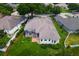 Aerial view of the home featuring a screened lanai, well-maintained lawn and mature landscaping at 33222 Irongate Dr, Leesburg, FL 34788