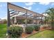 Spacious backyard with a screened-in lanai, featuring a pool and lush landscaping with shade trees at 3354 Truluck Pl, Oxford, FL 34484