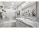Bright bathroom features a marble countertop, a large vanity mirror, and a shower-tub combination at 3354 Truluck Pl, Oxford, FL 34484