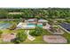 Aerial image of a community pool, playground, and basketball court surrounded by lush greenery and residential homes at 3354 Truluck Pl, Oxford, FL 34484