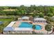 Aerial view of a community pool area with lounging spaces, surrounded by well-maintained landscaping and trees at 3354 Truluck Pl, Oxford, FL 34484