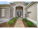 Inviting front entrance featuring a covered porch, decorated door, and landscaped walkway at 3354 Truluck Pl, Oxford, FL 34484