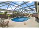 Beautiful in-ground pool with a relaxing waterfall feature in an enclosed screened-in lanai at 3354 Truluck Pl, Oxford, FL 34484