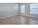 A bright, unfurnished bedroom with neutral paint, tile flooring, and two windows provides a blank canvas for personalization at 34107 Alameda Dr, Sorrento, FL 32776