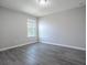 Neutral bedroom features an updated window and modern gray flooring at 34107 Alameda Dr, Sorrento, FL 32776