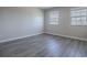 An empty bedroom with wood flooring and two windows providing ample natural light at 34107 Alameda Dr, Sorrento, FL 32776