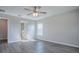 Bedroom showcasing modern wood-look floors, a ceiling fan, and a glimpse into a bathroom with a glass-enclosed shower at 34107 Alameda Dr, Sorrento, FL 32776