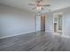 Spacious bedroom with wood-look flooring, a ceiling fan, and open access to a bathroom with granite countertops at 34107 Alameda Dr, Sorrento, FL 32776