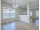 An airy dining area with neutral walls and tile floors has a chandelier and ample natural light from a large window at 34107 Alameda Dr, Sorrento, FL 32776