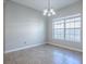 A bright dining area features tile flooring, a chandelier, a large window, and neutral decor at 34107 Alameda Dr, Sorrento, FL 32776