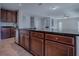 Kitchen island with dark wood cabinetry, granite countertops and stainless steel dishwasher at 34107 Alameda Dr, Sorrento, FL 32776